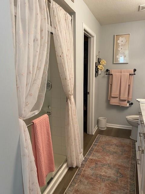 bathroom featuring a shower with curtain, vanity, toilet, and a textured ceiling