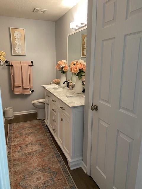 bathroom featuring vanity, toilet, and wood-type flooring