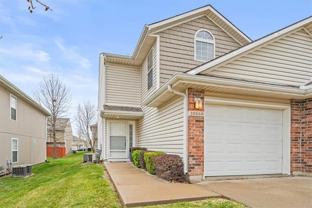 view of property featuring central AC, a garage, and a front yard