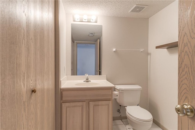 bathroom featuring vanity, tile patterned floors, a textured ceiling, and toilet