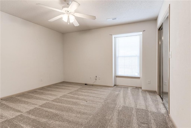 unfurnished room featuring carpet flooring, a textured ceiling, and ceiling fan