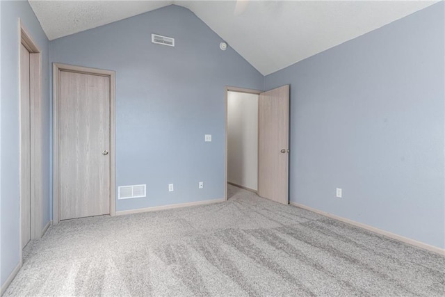 unfurnished bedroom featuring light colored carpet and vaulted ceiling