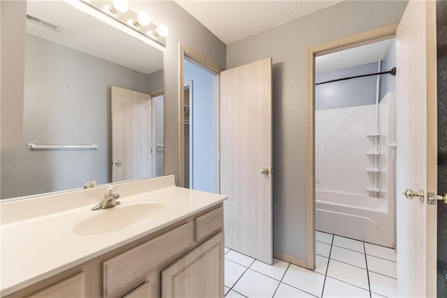 bathroom with tile patterned flooring, vanity, bathing tub / shower combination, and a textured ceiling