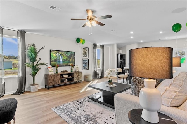 living room featuring ceiling fan and light hardwood / wood-style floors