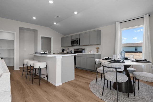 37887 W 207th Ter, Edgerton, KS 66021 - kitchen with stainless steel appliances, gray cabinetry, light wood-style flooring, vaulted ceiling, and light countertops