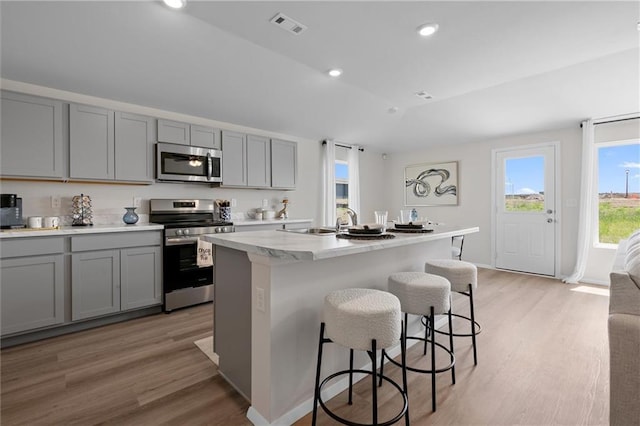 37887 W 207th Ter, Edgerton, KS 66021 - kitchen featuring stainless steel appliances, gray cabinetry, light wood-style flooring, a kitchen bar, and recessed lighting