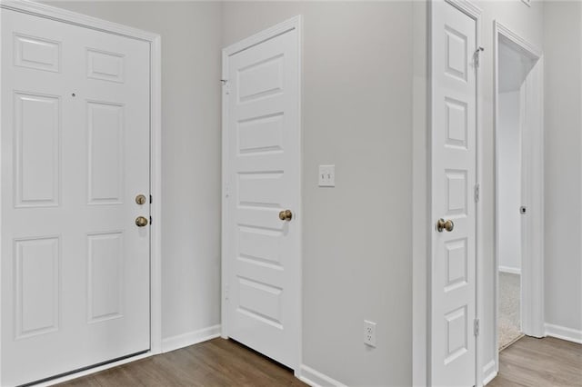 foyer entrance with baseboards and dark wood-type flooring