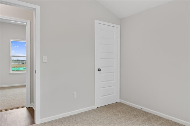 unfurnished bedroom with baseboards, carpet floors, and vaulted ceiling