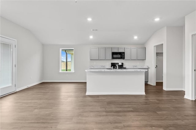 kitchen featuring range, visible vents, dark wood finished floors, black microwave, and gray cabinetry