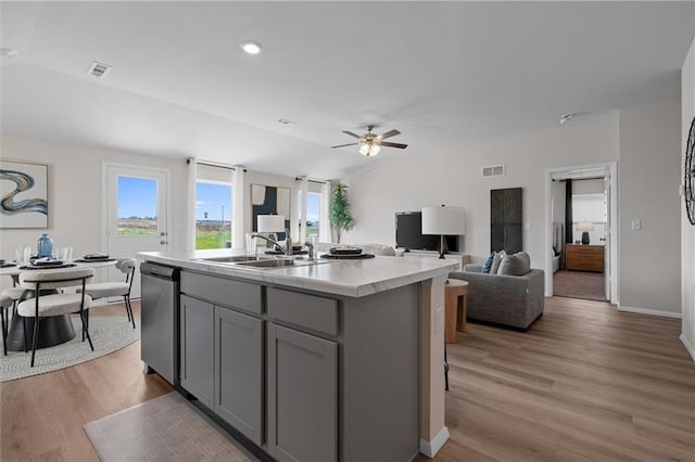 37767 W 207th Ter, Edgerton, KS 66021 - kitchen with gray cabinetry, dishwasher, light wood-style flooring, light countertops, and a center island with sink