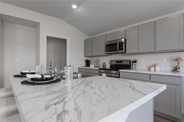 37767 W 207th Ter, Edgerton, KS 66021 - kitchen with stainless steel appliances, gray cabinets, vaulted ceiling, and light stone counters