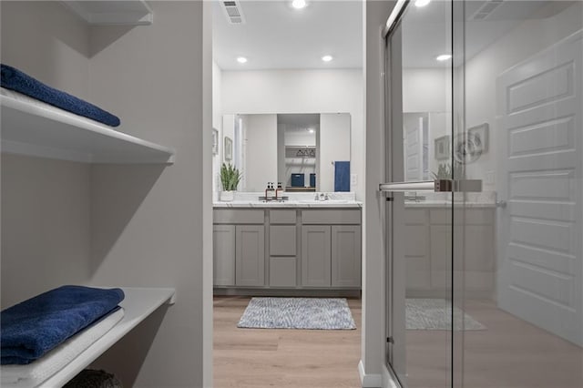 37767 W 207th Ter, Edgerton, KS 66021 - full bathroom featuring wood finished floors, double vanity, a shower stall, and recessed lighting