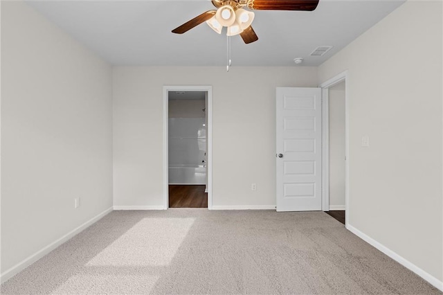 unfurnished bedroom with ceiling fan, connected bathroom, and carpet flooring