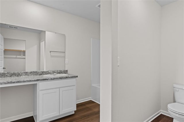 bathroom with toilet, vanity, and hardwood / wood-style flooring