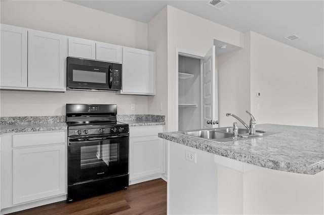 kitchen featuring black appliances, white cabinets, dark wood-type flooring, and sink