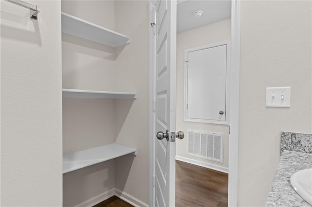 spacious closet with sink and dark hardwood / wood-style floors