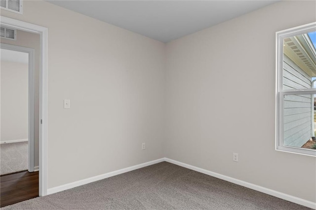 unfurnished room featuring dark colored carpet