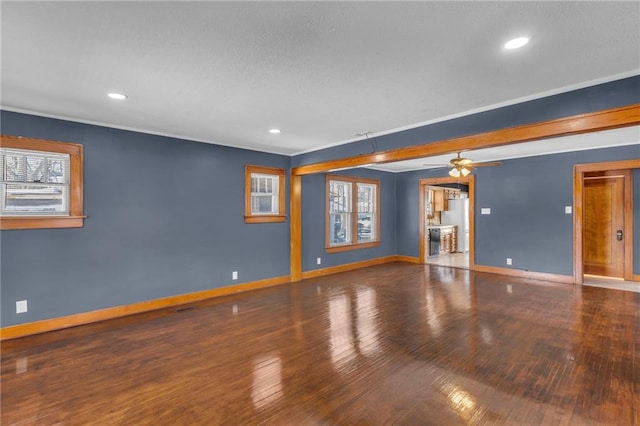 empty room featuring ceiling fan, dark hardwood / wood-style flooring, and a healthy amount of sunlight