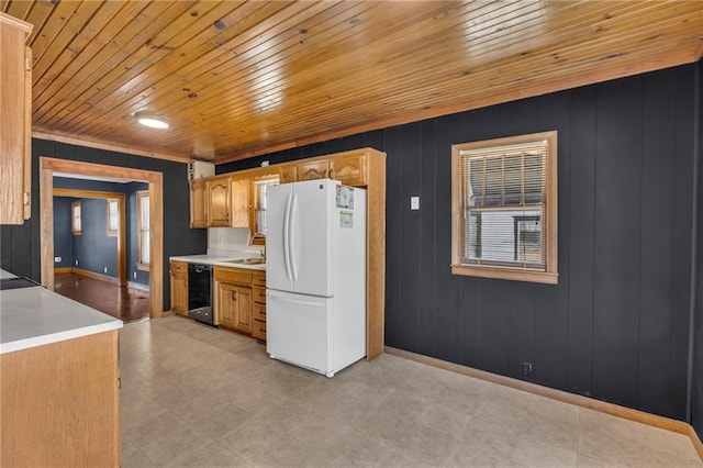 kitchen featuring sink, dishwasher, wood walls, and white fridge