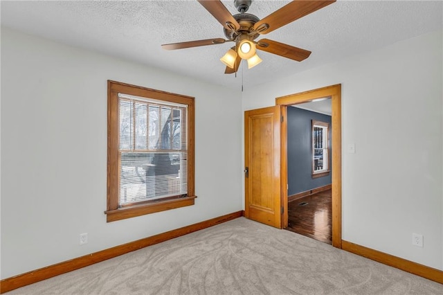 unfurnished bedroom featuring ceiling fan, a textured ceiling, and light carpet