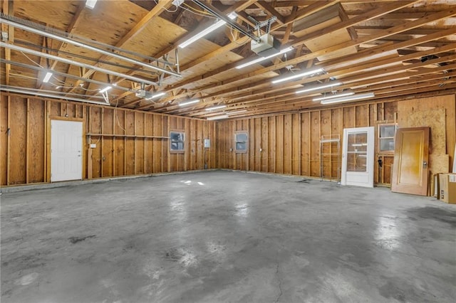 garage featuring a garage door opener and wood walls