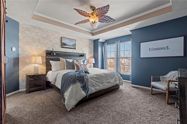 bedroom with ceiling fan, crown molding, a tray ceiling, and carpet flooring