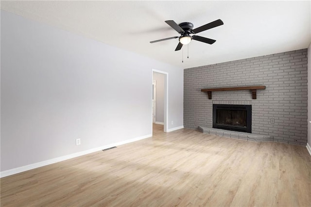 unfurnished living room with ceiling fan, a fireplace, and light hardwood / wood-style flooring