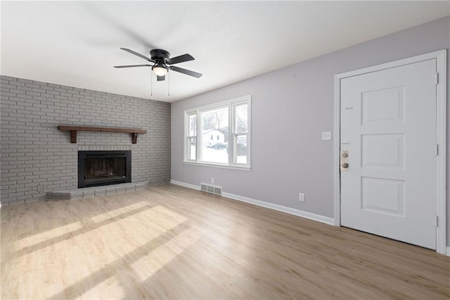 unfurnished living room featuring a fireplace, light hardwood / wood-style flooring, and ceiling fan