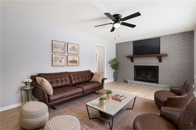 living room featuring ceiling fan, hardwood / wood-style floors, and a fireplace