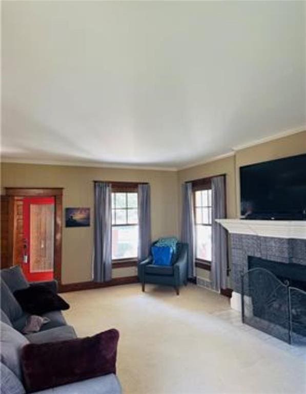 carpeted living room featuring a fireplace, a wealth of natural light, and crown molding