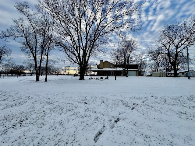 snowy yard featuring a shed