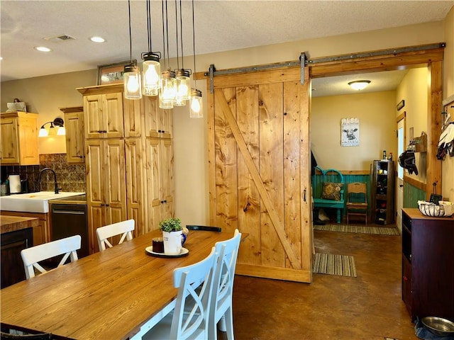 dining space with a barn door and sink