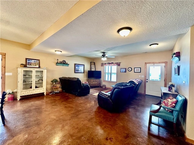 living room featuring ceiling fan and a textured ceiling