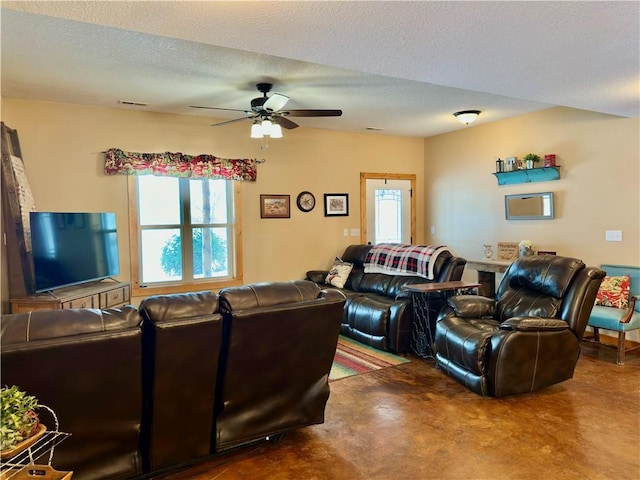 living room with ceiling fan and a textured ceiling