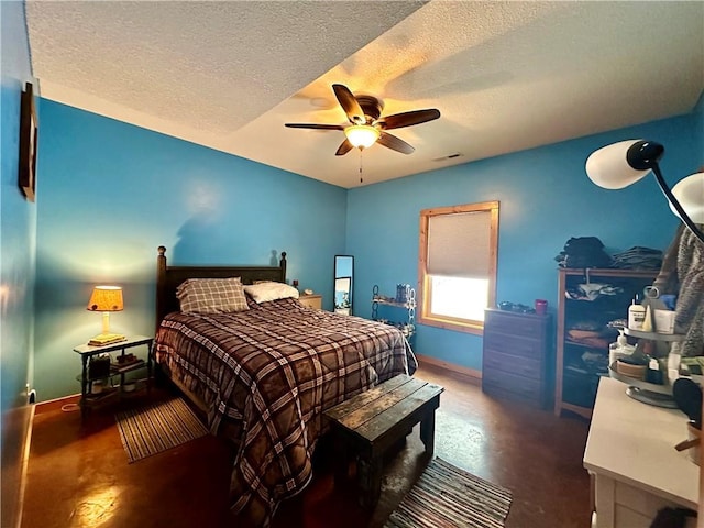 bedroom with ceiling fan, a textured ceiling, and concrete flooring