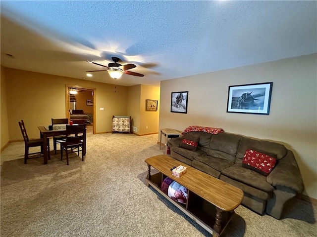 living room with a textured ceiling, ceiling fan, and carpet floors