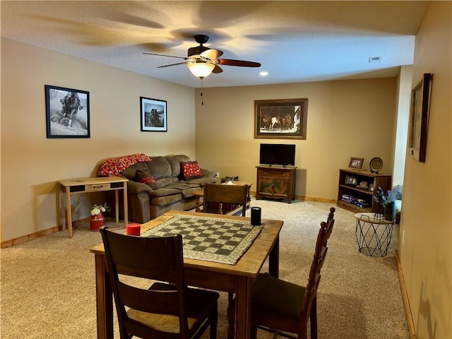 living room with a textured ceiling, ceiling fan, and carpet