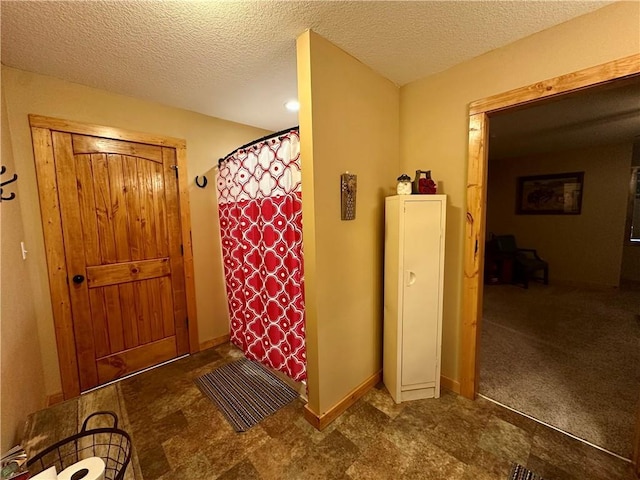 bathroom with a textured ceiling and a shower with shower curtain