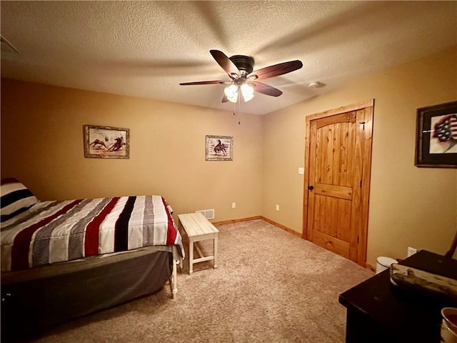 carpeted bedroom with ceiling fan and a textured ceiling