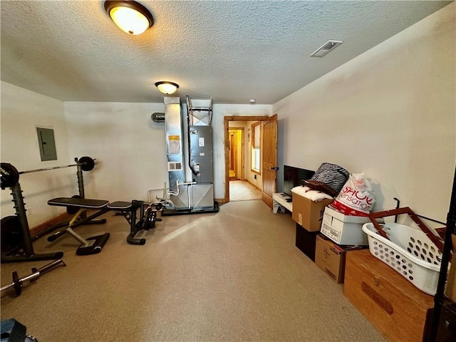 exercise room featuring a textured ceiling and electric panel