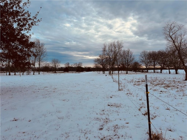 snowy yard with a rural view