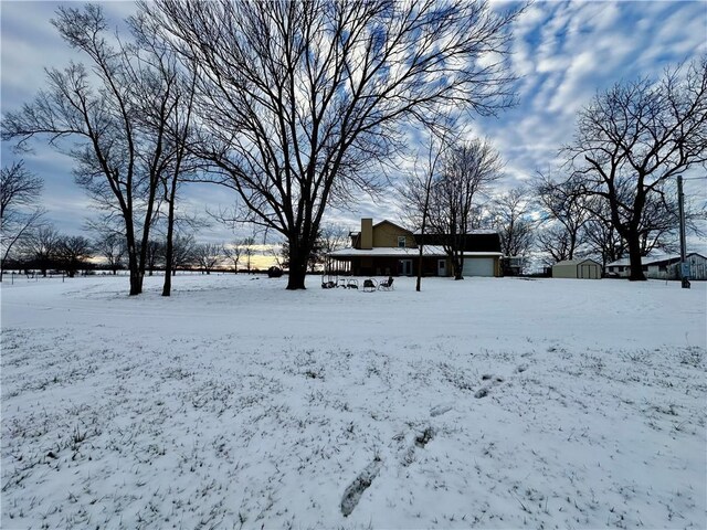 snowy yard featuring a shed