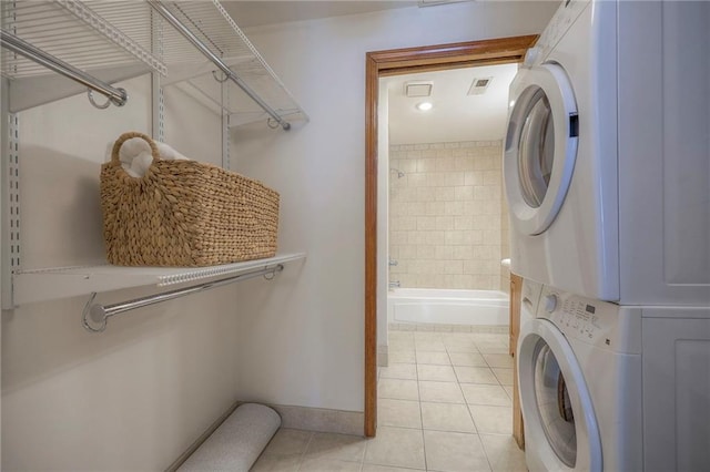 washroom with stacked washer and clothes dryer and light tile patterned floors