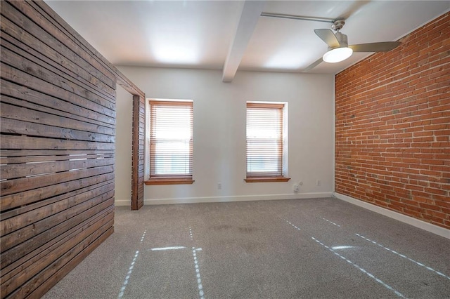 spare room with ceiling fan, brick wall, light carpet, and beam ceiling