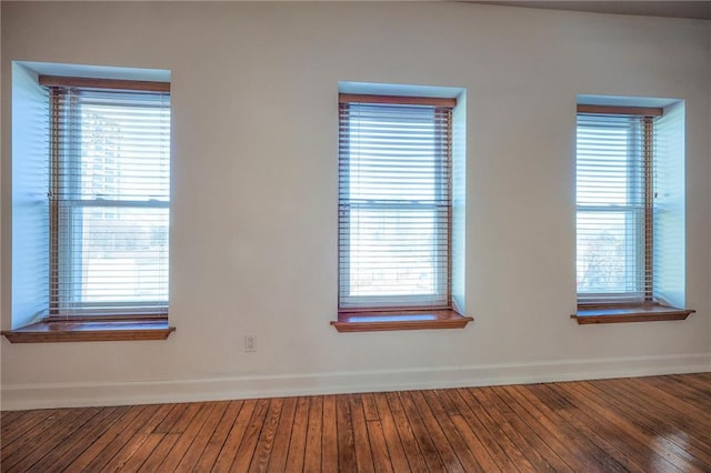 spare room featuring a healthy amount of sunlight and wood-type flooring