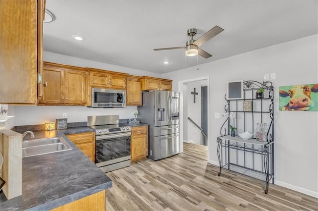 kitchen featuring light wood-type flooring, ceiling fan, stainless steel appliances, and sink