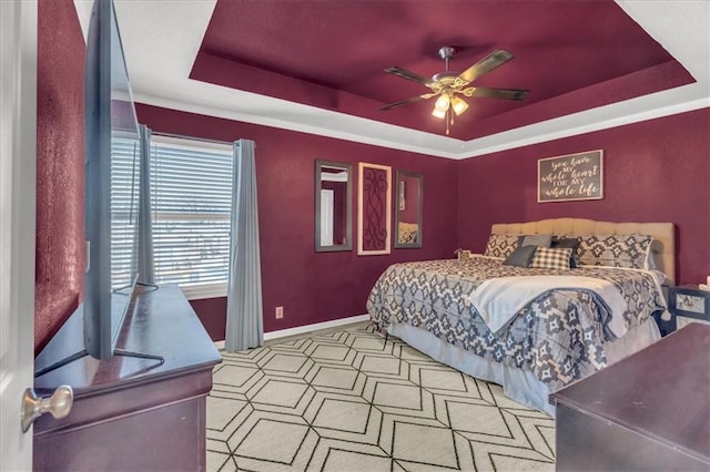 bedroom with ceiling fan and a raised ceiling