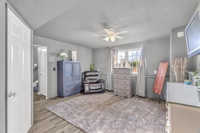 interior space with ceiling fan, a textured ceiling, and light hardwood / wood-style flooring