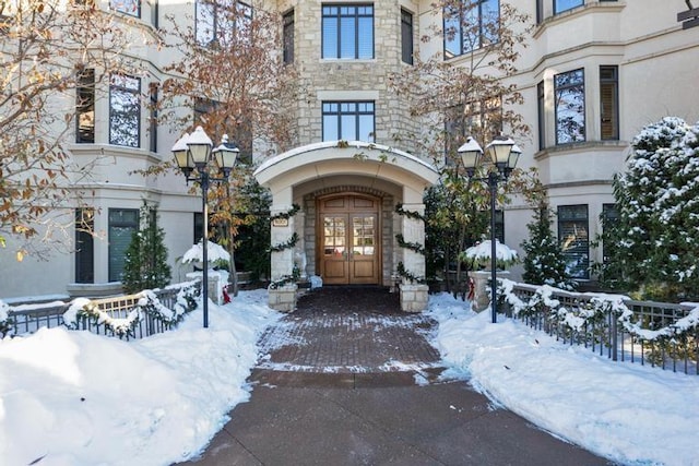 snow covered property entrance featuring french doors