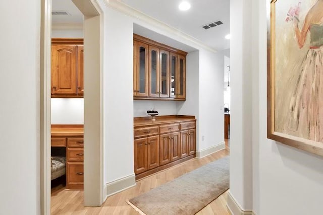 hall featuring light hardwood / wood-style floors and ornamental molding